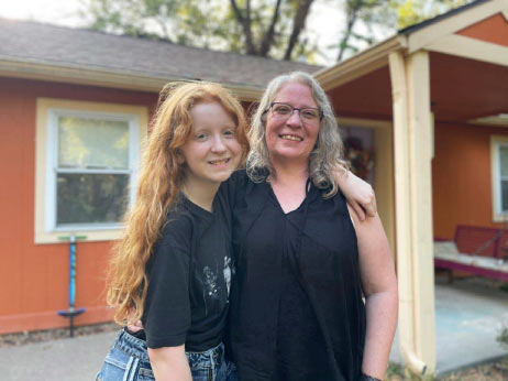 Melissa and daughter standing in front of new home